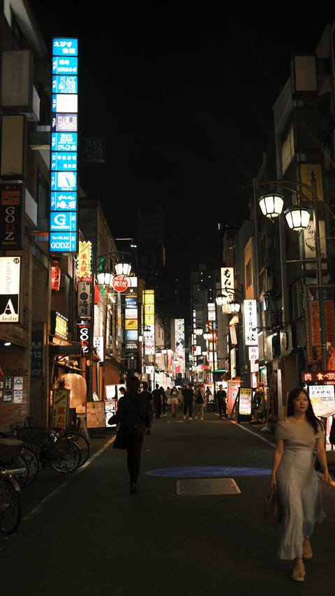 Maria on a neon-lit Shinjuku street at night
