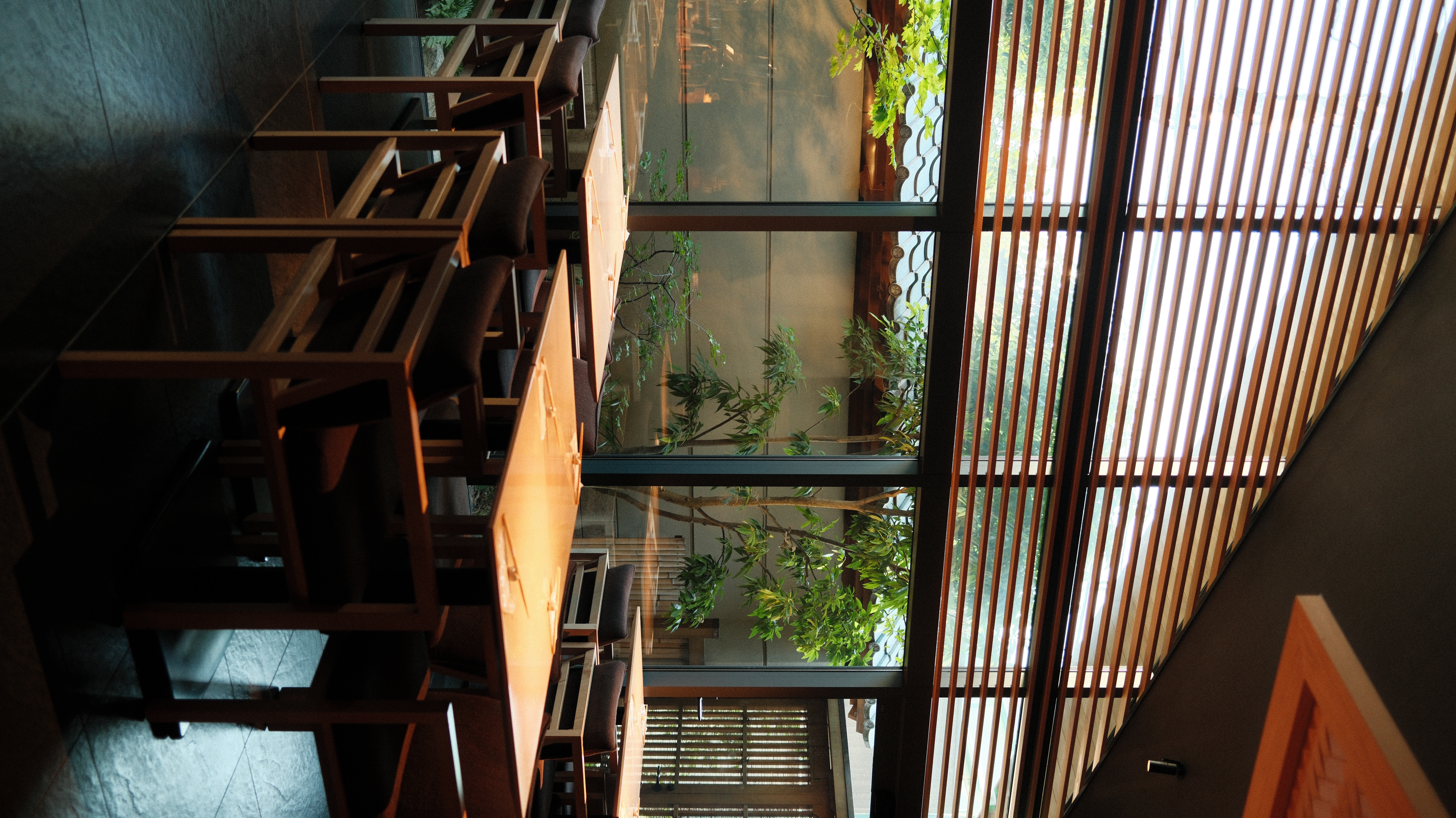 Tokyo cafe interior with wooden chairs and glass ceiling, natural light