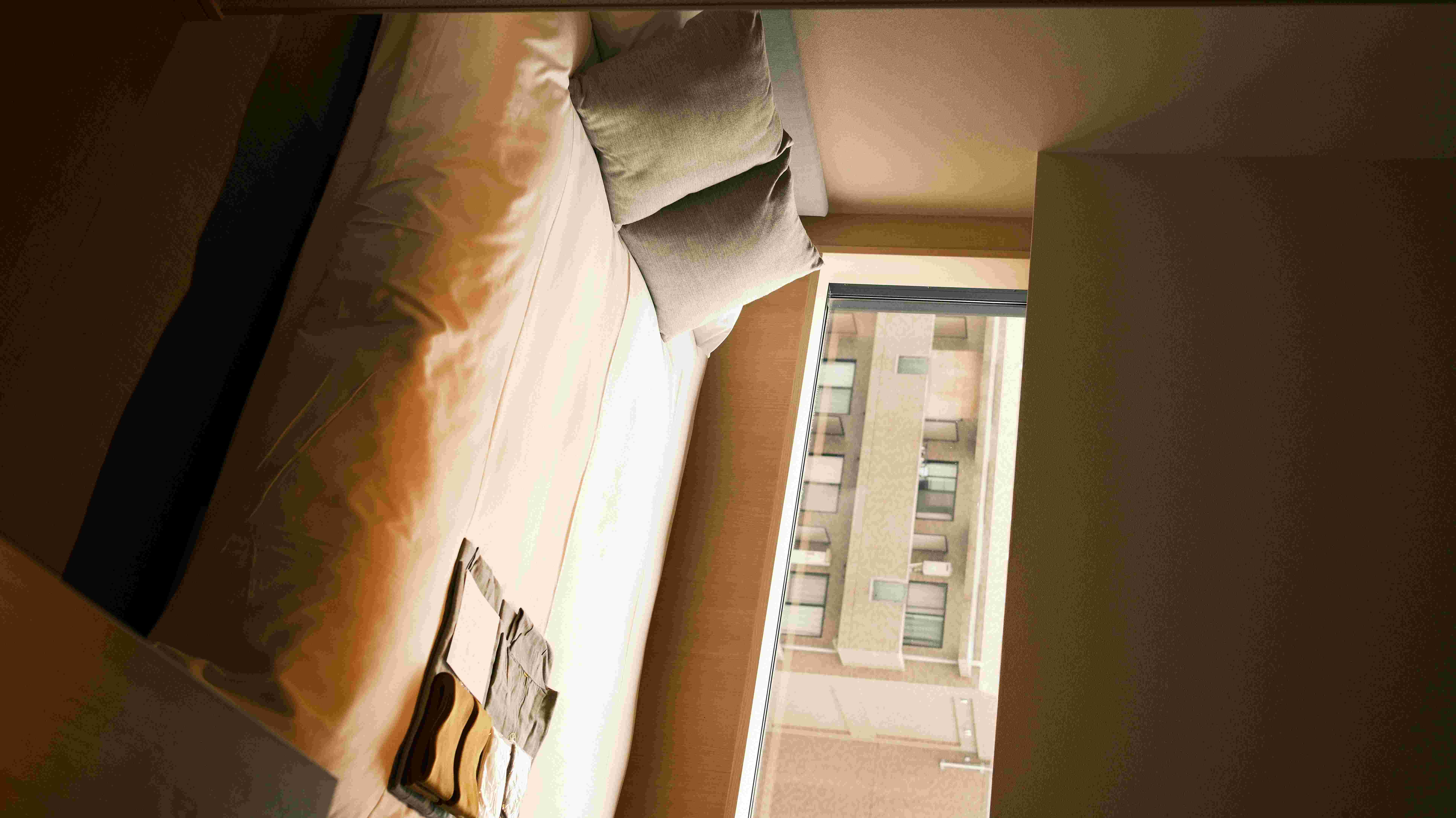 Hotel room bed with a view of Tokyo rooftops