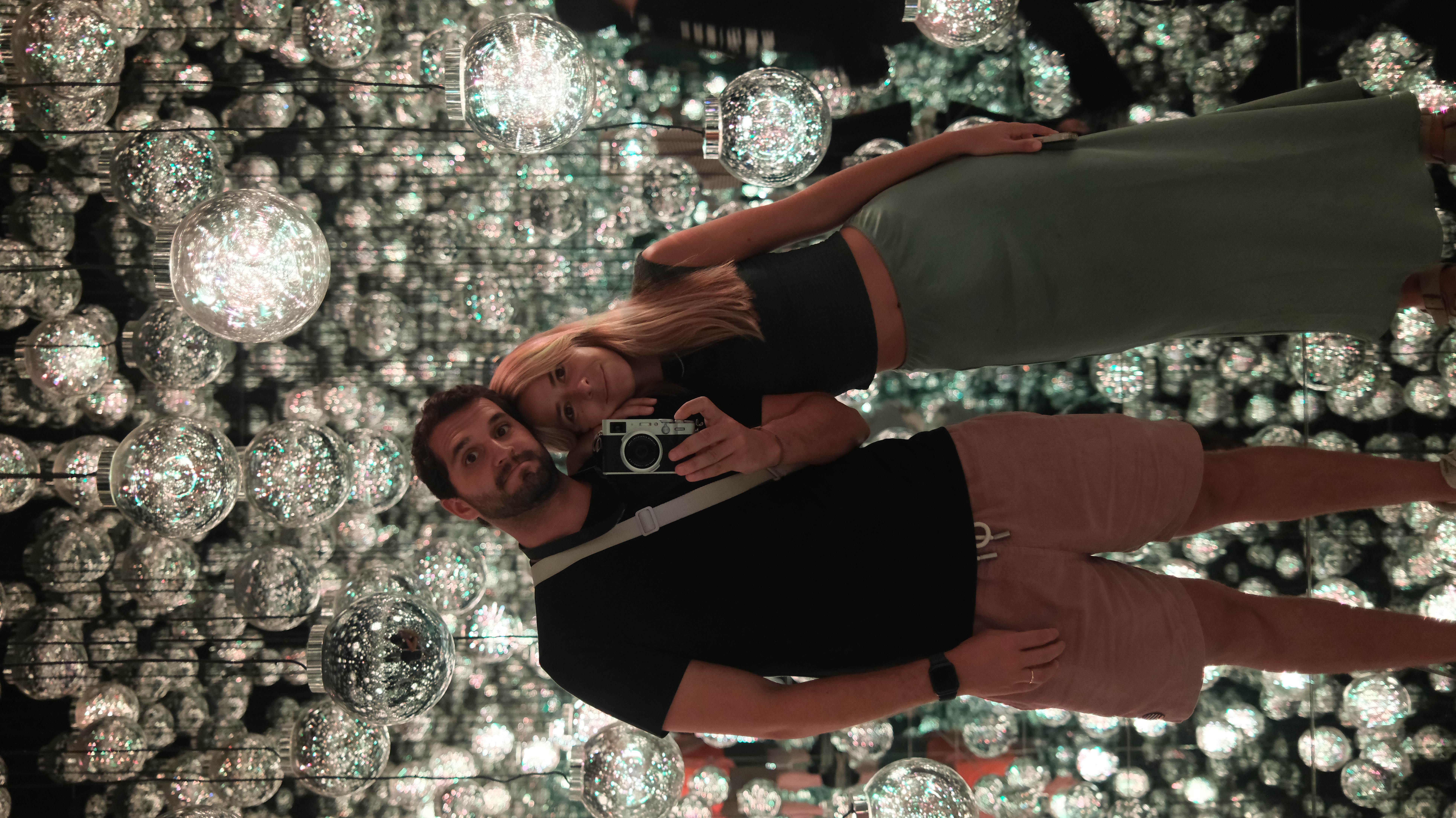 Maria and Zé together inside TeamLab Borderless mirror ball room